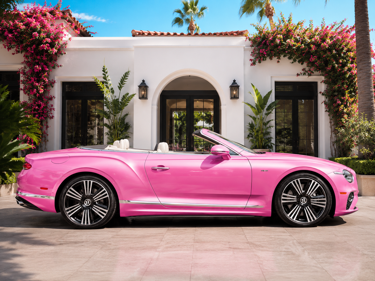 Pink Bentley Continental GT convertible parked outside a white villa